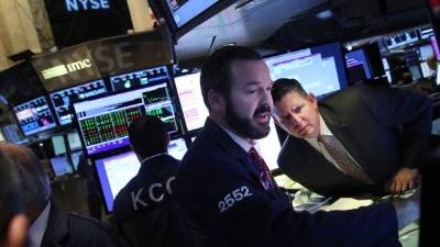 Corredores de bolsas revisan el movimiento de las acciones en el parqué de Nueva York