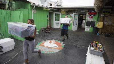 ST MARKS, FL - SEPTEMBER 09: Emily Steele, left, and Chris Muse remove restaurant supplies from the Riverside Cafe in preparation for Hurricane Irma September 9, 2017 in the Florida panhandle town of St Marks, Florida. Current tracks for Hurricane Irma shows that it will hit Florida's west coast on Sunday. Mark Wallheiser/Getty Images/AFP== FOR NEWSPAPERS, INTERNET, TELCOS & TELEVISION USE ONLY ==
