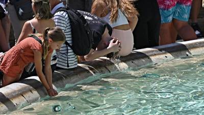 Un grupo de turistas se refresca en la fontana de Trevi ante las temperaturas extremas registradas este martes en Europa.