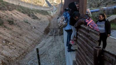 Fotografía de archivo de migrantes cruzando el cerco sobre la frontera México - EEUU.