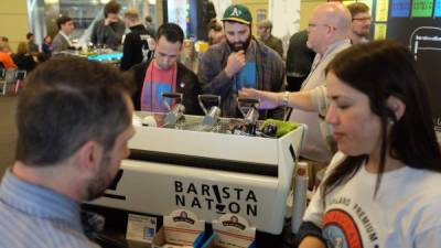 Baristas participantes en la feria sirven café a los visitantes en Seattle.