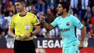 El delantero uruguayo del Barcelona Luis Suárez (d) habla con el colegiado Alberto Undiano Mallenco en un partido. EFE/Archivo