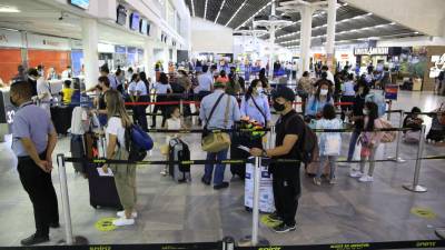 Viajeros hacen fila para el chequeo en el aeropuerto Ramon Villeda Morales.