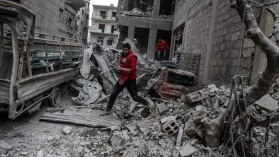 EPA7685. DUMA (SIRIA), 22/02/2018.- Un voluntario de Media Luna Roja corre tras un bombardeo en Duma, feudo rebelde de Guta Oriental (Siria) hoy, 22 de febrero de 2018. Al menos 106 personas murieron este martes por ataques contra Guta Oriental, en el tercer día de escalada de los bombardeos y disparos de artillería, que pueden ser preludio de una ofensiva gubernamental siria. EFE/ Mohammed Badra