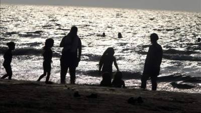 Una familia disfrutando de la playa municipal de Puerto Cortés, norte de Honduras. EFE/Archivo