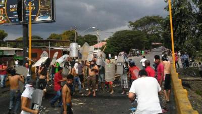 Manifestantes muestran los escudos que le quitaron a las fuerzas del orden en El Progreso.
