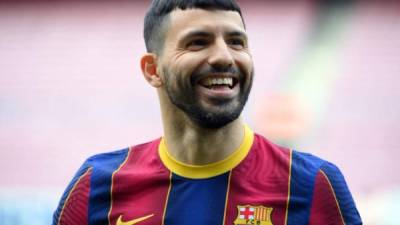 Former Manchester City's player, Argentine forward Sergio Aguero smiles as he poses on the pitch of the Camp Nou stadium in Barcelona during his official presentation as new player of FC Barcelona on May 31, 2021. - Barcelona have signed Argentinian forward Sergio Aguero on a deal until 2023, the Catalan giants announced today. In a statement, Barca said that Aguero, who arrives after a decade at Manchester City, has a buy-out clause 'set at 100 million euros ($122 million).' (Photo by LLUIS GENE / AFP)