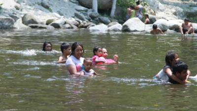 Personas bañan en el río Zapotal.