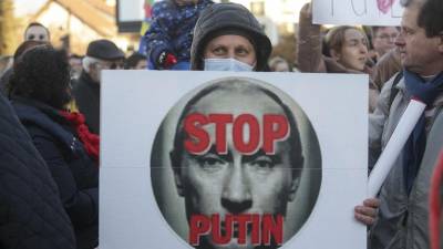 Un manifestante sostiene una pancarta durante una manifestación en apoyo de Ucrania frente a la Embajada de Rusia contra la operación militar de Rusia en Ucrania.