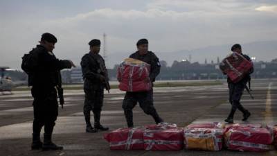 Miembros de las fuerzas de seguridad de Guatemala trasladan hoy, miércoles 23 de octubre de 2013, paquetes de cocaína confiscados durante un operativo antidrogas en el departamento de Izabal, en el Caribe de Guatemala. Fuentes del Ministerio Público (Fiscalía) explicaron que el alijo, hasta ahora suma 975 kilos, se encontró la noche del martes en un camión que llegó al país posiblemente procedente de Honduras, país al que había llegado desde Colombia. EFE/
