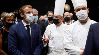 French President Emmanuel Macron (L) speaks with French chefs Regis Marcon (C) and Jerome Bocuse (R) during a visit at the International Catering, Hotel and Food Trade Fair (SIRHA - salon international de la restauration, de l'hotellerie et de l'alimentation) at the Eurexpo hall in Lyon, central eastern France, on September 27, 2021. (Photo by Ludovic MARIN / POOL / AFP)