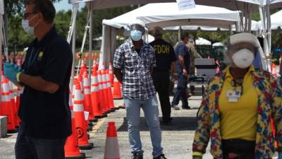 People with and without a face masks enjoy the bay path amid the novel coronavirus (COVID-19) pandemic in South Bay, Miami, on May 20, 2020. - Florida begins to slowly get back to business after a coronavirus lockdown. (Photo by CHANDAN KHANNA / AFP)