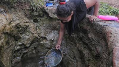Mujeres lavan hoy ropa con el agua de un pozo que excavaron, en Tegucigalpa (Honduras).