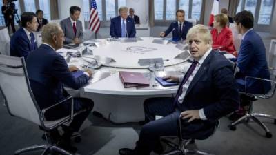 (L-R) Italy's Prime Minister Giuseppe Conte, European Council President Donald Tusk, Japan's Prime Minister Shinzo Abe, US President Donald Trump, France's President Emmanuel Macron, Britain's Prime Minister Boris Johnson, Germany's Chancellor Angela Merkel and Canada's Prime Minister Justin Trudeau attend a working session on 'International Economy and Trade, and International Security Agenda' in Biarritz, south-west France on August 25, 2019, on the second day of the annual G7 Summit attended by the leaders of the world's seven richest democracies, Britain, Canada, France, Germany, Italy, Japan and the United States. (Photo by Andrew Harnik / POOL / AFP)