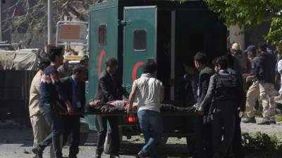 TOPSHOT - A car bomb attack victim on a stretcher is carried to an ambulance at the site of the blast in Kabul on May 31, 2017.A massive blast rocked Kabul's diplomatic quarter during the morning rush hour on May 31, the latest attack to hit the Afghan capital. / AFP PHOTO / SHAH MARAI