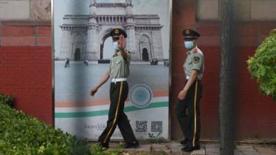 Two Chinese paramilitary police officers patrol outside the Indian embassy in Beijing on June 16, 2020. - China on June 16 accused India of crossing a disputed border between the two countries, as the Indian army said three of its soldiers had been killed in violent clashes. (Photo by GREG BAKER / AFP)