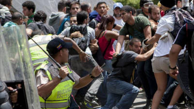 Manifestantes opositores se enfrentan a miembros de la Policía Nacional Bolivariana (PNB) tras una concentración convocada por las organizaciones opositoras estudiantiles en Caracas el 20 de marzo de 2014. EFE