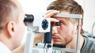 Ophthalmology concept. Male patient under eye vision examination in eyesight ophthalmological correction clinic