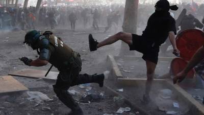 Manifestantes se enfrentan a la Policía este martes en la céntrica Plaza Italia de Santiago, Chile, durante una nueva jornada de movilizaciones a nivel nacional.