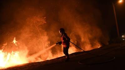 Un hombre trata de sofocar las llamas del incendio desatado la población de Almeidinha, en el distrito de Guarda, cerca de la frontera con la provincia española de Salamanca, donde las llamas han llegado hasta el casco urbano. EFE/Carlos García