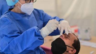 A health worker conducts a SARS-CoV-2 rapid antigen test at a temporary tent, in Mexico City on April 6, 2021. (Photo by PEDRO PARDO / AFP)