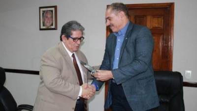 Jacobo Paz entrega una placa a Gustavo Cárdenas.