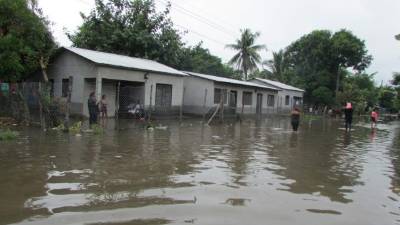 Vecinos de un barrio de la aldea Monjarás, en Choluteca caminan por una de las calles inundadas por las últimas lluvias.