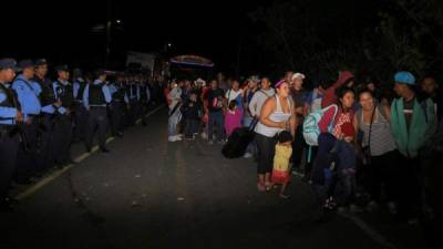 Ciudadanos hondureños pasan por un reten policial hoy, en la aduana de Agua Caliente, frontera entre Honduras y Guatemala.EFE