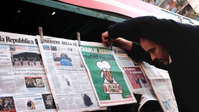 Un vendedor de periódicos muestra la última edición de la revista satírica francesa Charlie Hebdo en su kiosco en Roma el 14 de enero de 2015. AFP