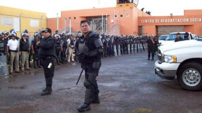Miembros de la Policía mexicana vigilan los alrededores de un penal el 16 de mayo de 2009, en el estado de Zacatecas, al norte de México, donde un grupo de 20 personas armadas y vestidas con uniformes de agentes federales rescataron a 53 presos en horas de la madurgada.