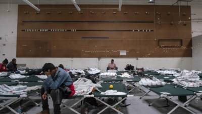 Migrants from different Latin American countries sit on cots in the Casa del Refugiado, or The House of Refugee, a new centre opened by the Annunciation House to help the large flow of migrants being released by the United States Border Patrol and Immigration and Customs Enforcement in El Paso, Texas on April 24, 2019. - The 125,000 foot space will accomodate about 500 migrants, with plans to expand for up to 1,500. While this is larger then other centres in the El Paso area, Father Ruben Garcia the director of Annunciation house says that they will still rely on churches around the community for help housing migrants. According to the CBP, border patrol agents apprehended 92,607 people along the southwest border in March, up from 66,884 in February. US President Donald Trump, who has made immigration the core of his message to his conservative base, said on Twitter that 'a very big Caravan of over 20,000 people' is making its way through Mexico toward the United States. (Photo by Paul Ratje / AFP)