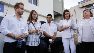Familiares y amigos del expresidente salvadoreño Francisco Flores en una vigilia a las puertas del centro médico para pedir por su recuperación, en San Salvador.