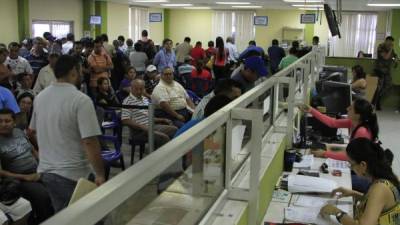 Los usuarios esperan en el área de entregas de RTN en las oficinas de la DEI en San Pedro Sula. Foto: Franklyn Muñoz.