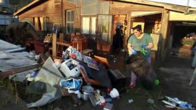 Una residente saca sus pertenencias para secarlas afuera de su casa en Concón, a unos 110 km al noroeste de Santiago.