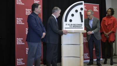 Los miembros del Boletín de Científicos Atómicos, Herb Lin (i), Robert Socolow (2-d), y Suzet McKinney (d), y el expresidente colombiano, Juan Manuel Santos, participan en una conferencia de prensa para anunciar el ‘Reloj del Juicio Final’.