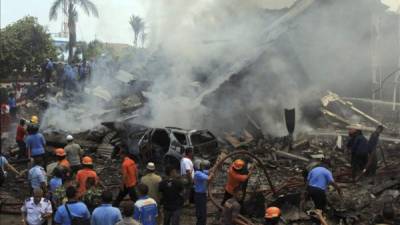 Miembros de los servicios de rescate indonesios trabajan en la extinción del incendio tras estrellarse un avión militar de transporte del Ejército indonesio en Medan, Sumatra. efe