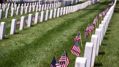 El cementerio nacional de Arlington adornado con banderas estadounidenses en las tumbas de los soldados caídos.