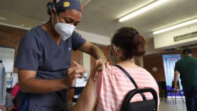 En la Universidad Católica de San Pedro Sula, una enfermera aplica la vacuna a una señora. Fotos: Melvin Cubas.
