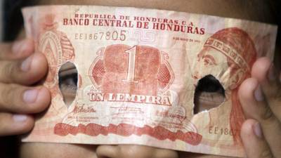 Un niño juega y se coloca como máscara un billete de un Lempira, moneda local hoy, jueves 21 de noviembre de 2013, en Tegucigalpa (Honduras). EFE