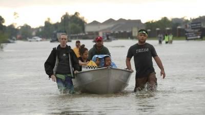 HOUSTON, TX - AUGUST 29: The Tellez family is evacuated from their home after severe flooding following Hurricane Harvey in north Houston August 29, 2017 in Houston, Texas. Harvey, which made landfall north of Corpus Christi late Friday evening, is expected to dump upwards of 40 inches of rain over the next couple of days. Win McNamee/Getty Images/AFP== FOR NEWSPAPERS, INTERNET, TELCOS & TELEVISION USE ONLY ==