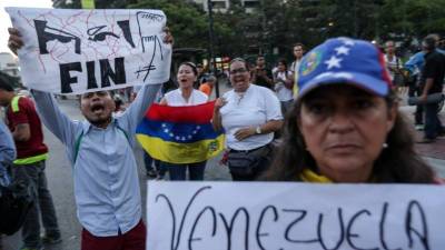 Caracas fue el viernes escenario de dos pequeñas protestas en contra de la decisión del Tribunal Supremo de Justicia (TSJ) en la que se atribuye la facultad de asumir las competencias del Parlamento, controlado por la oposición, alegando que la Cámara sigue en 'desacato'. EFE/CRISTIAN HERNÁNDEZ