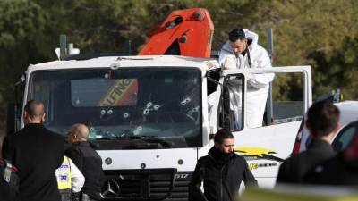EDITORS NOTE: Graphic content / An Israeli forensics expert gathers evidence as security forces and emergency personnel gather at the site of a vehicle-ramming attack in Jerusalem on January 8, 2017.Four Israeli soldiers were killed when they were run down by a truck in Jerusalem in what police were treating as a deliberate attack, a medic at the scene told AFP. / AFP PHOTO / MENAHEM KAHANA
