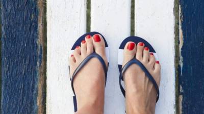 Female feet with flip flops on the jetty. Top view