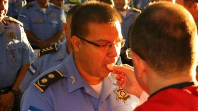 Un oficial de la Policía Nacional comulga ante un sacerdote durante una misa oficiada en Tegucigalpa.
