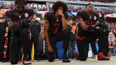 El exmariscal de campo Colin Kaepernick (centro) inició con las protestas durante el himno en 2016./AFP.