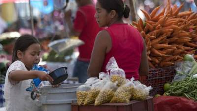 Una madre campesina junto a su hija en la Feria del Agricultor en Tegucigalpa. EFE/Archivo