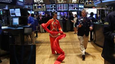 Danzante china en el piso de la bolsa de Nueva York. China contribuyó a la caída de los índices bursátiles.