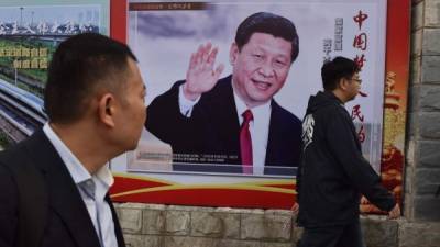 Un póster con la imagen de Xi saluda a los transeúntes en una calle de Pekín.