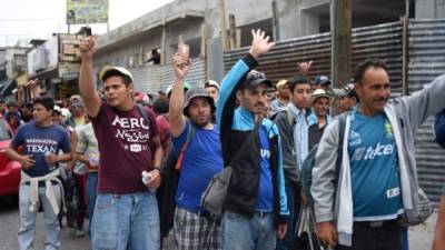 Honduran migrants heading to the United States hold up their hands as they arrive at the Casa del Migrante (Migrant's House) in Guatemala City on October 17, 2018. - A migrant caravan set out on October 13 from the impoverished, violence-plagued country and was headed north on the long journey through Guatemala and Mexico to the US border. President Donald Trump warned Honduras he will cut millions of dollars in aid if the group of about 2,000 migrants is allowed to reach the United States. (Photo by JOHAN ORDONEZ / AFP)