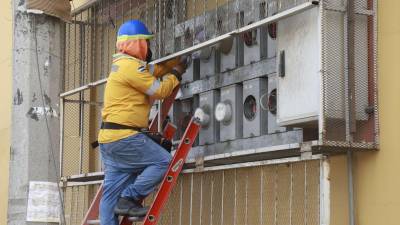 Un trabajador del sector eléctrico revisa los medidores de energía de un edificio.